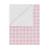 Blush Gingham minky baby blanket draped over a crib