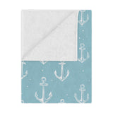 Nautical anchor minky baby blanket draped over a crib