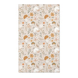 Floral nursery area rug in ochre and sage on warm oat