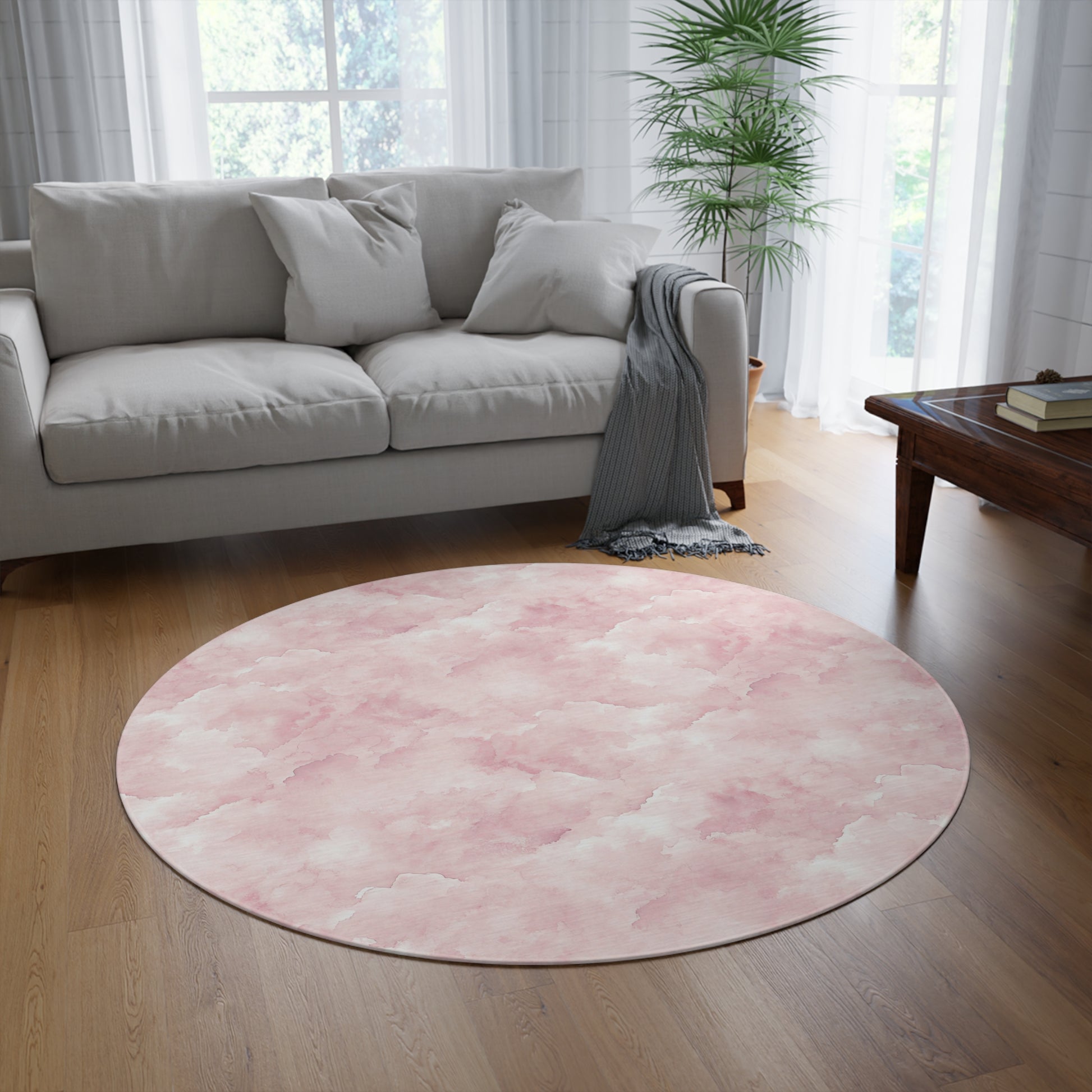 Pink watercolor clouds round rug styled under a nursery crib