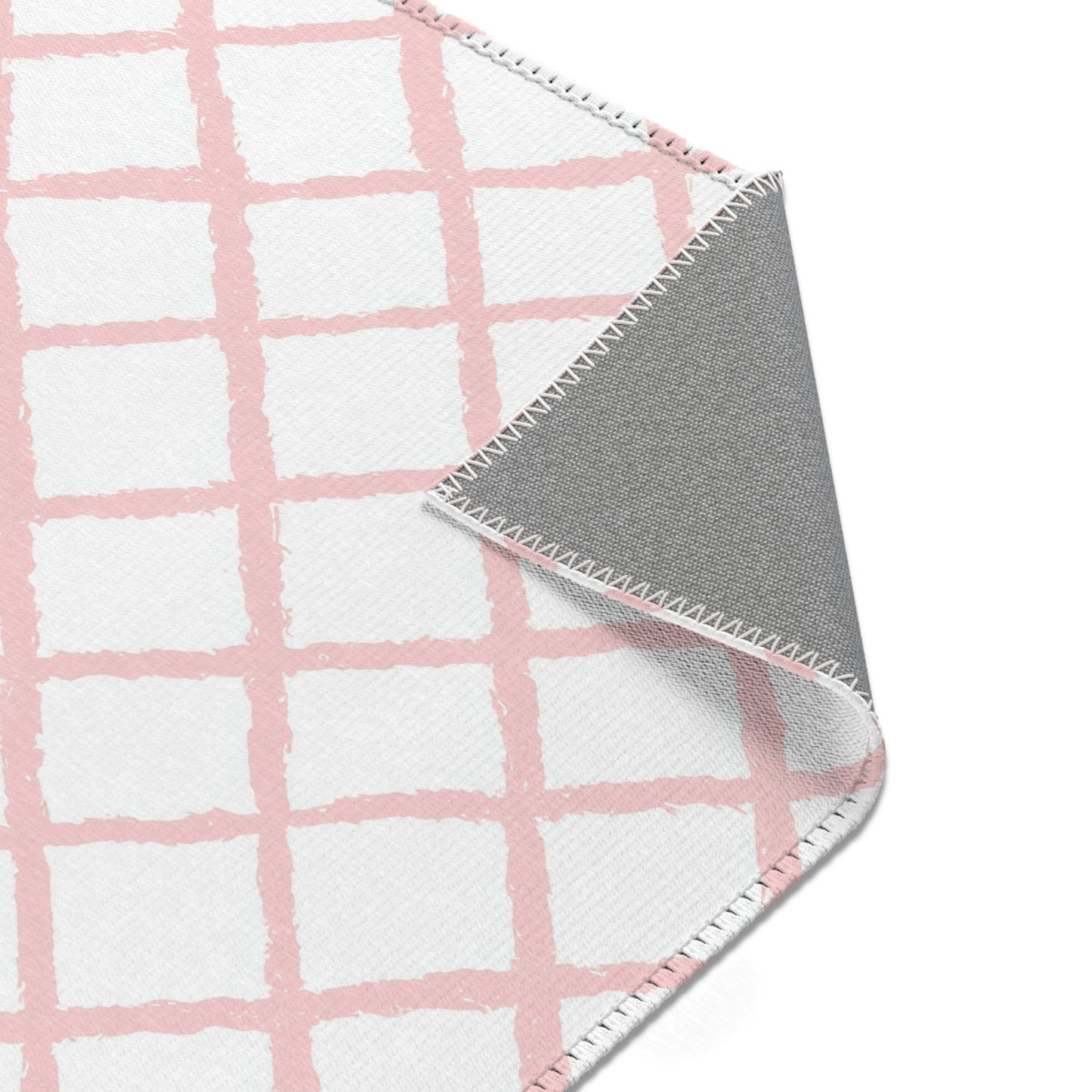 Pink trellis area rug styled with nursery furniture