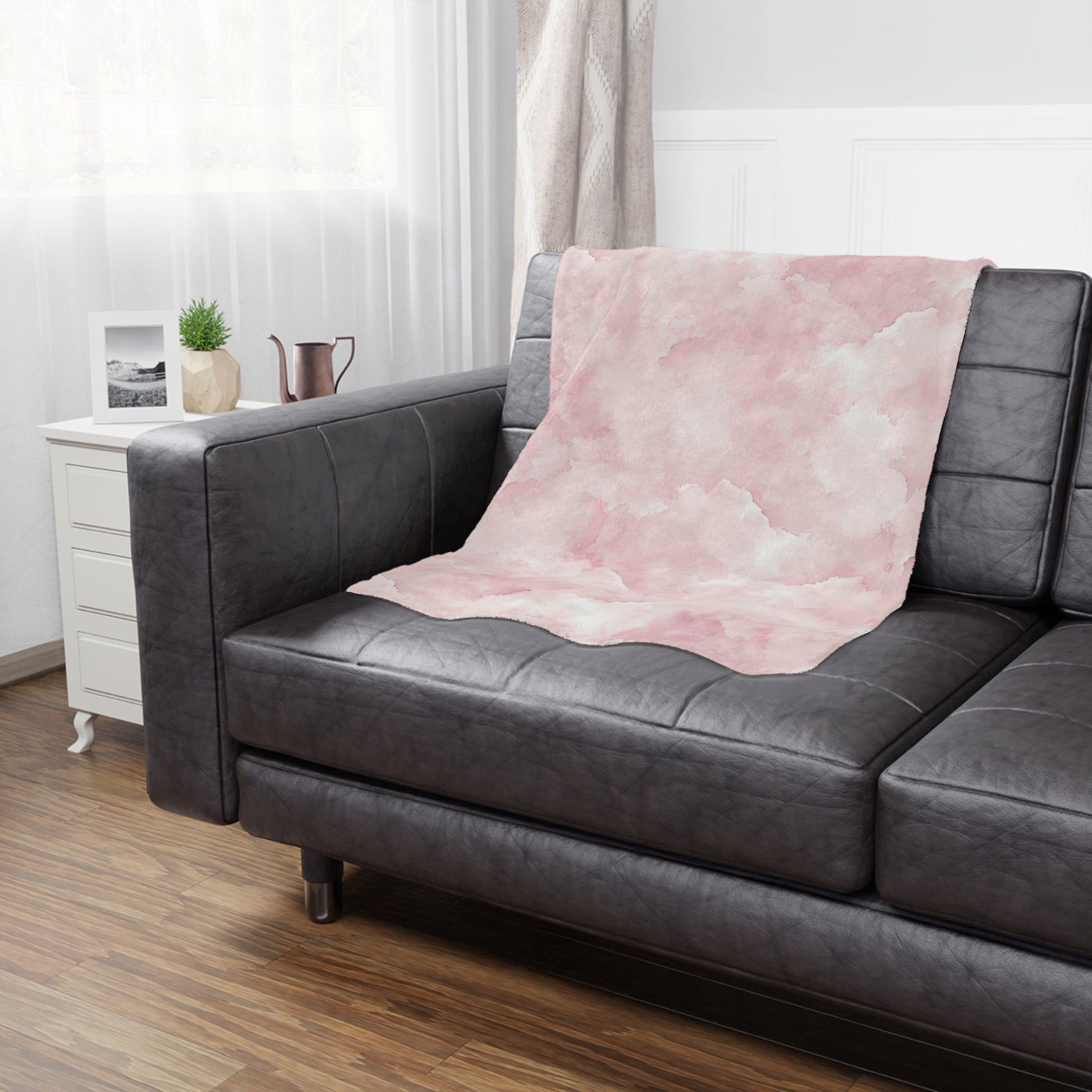 Pink watercolor clouds baby blanket styled in a nursery