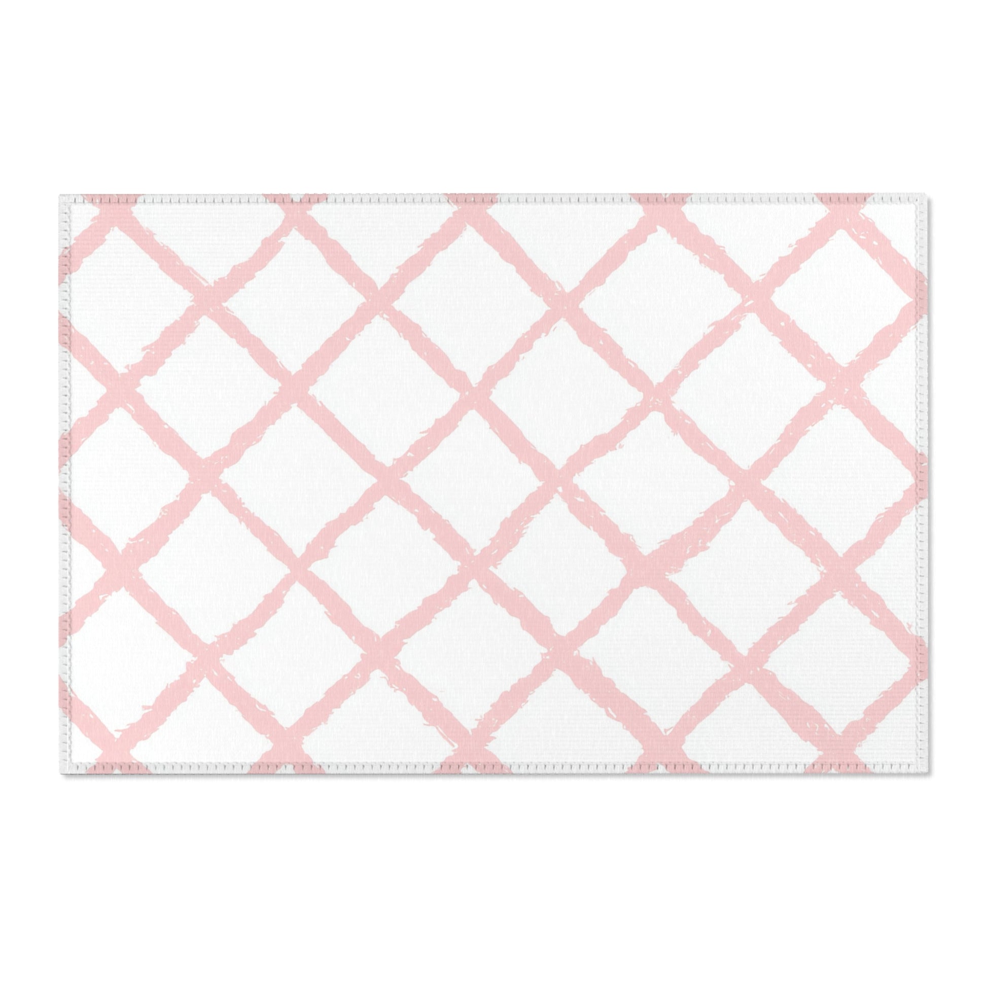 Washable pink trellis area rug under a nursery crib