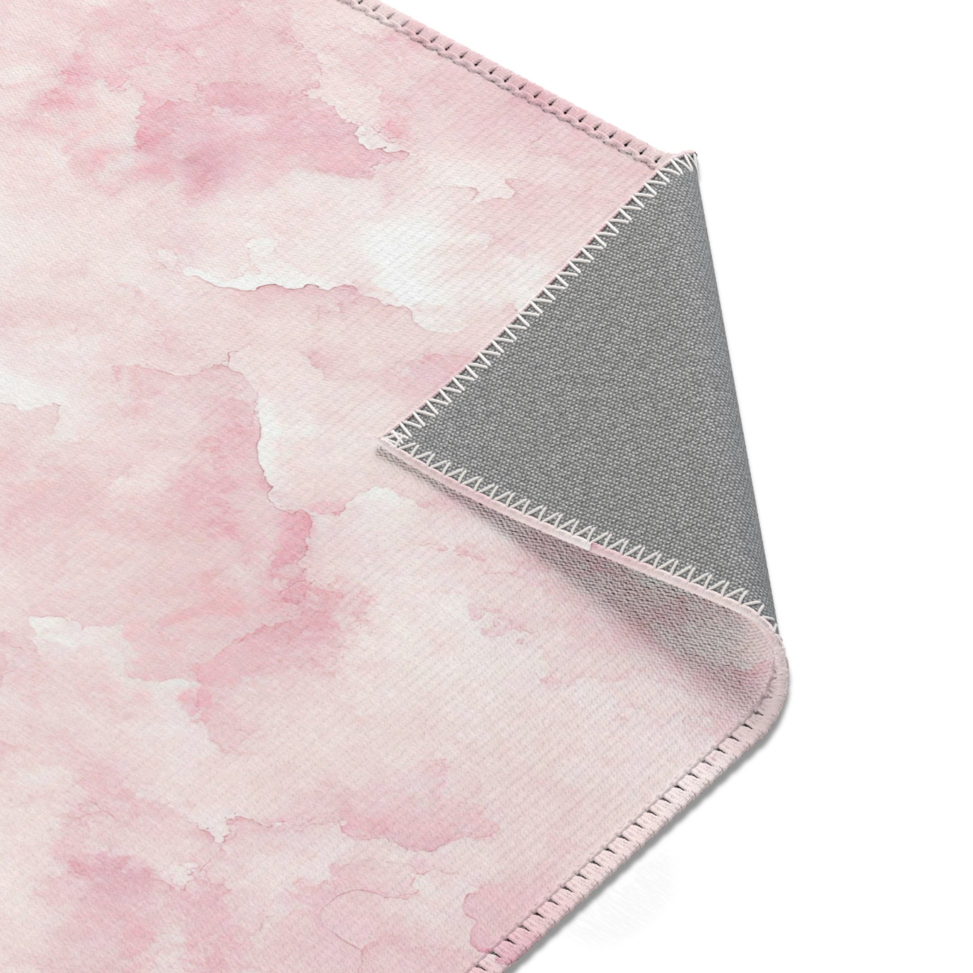 Pink watercolor clouds area rug styled with nursery furniture