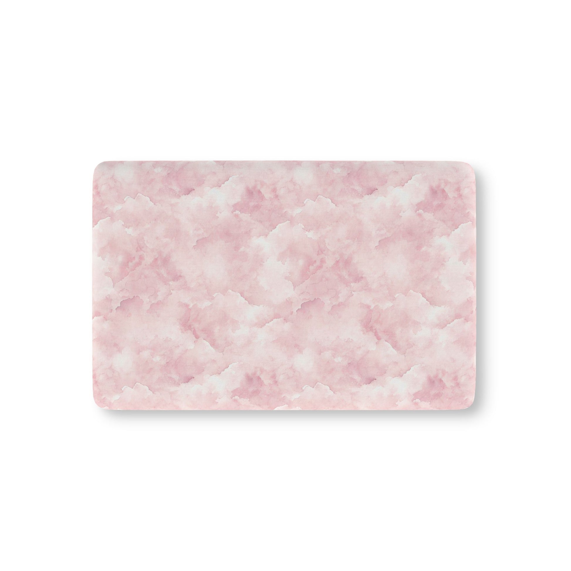 Pink watercolor clouds fitted crib sheet on a nursery crib mattress