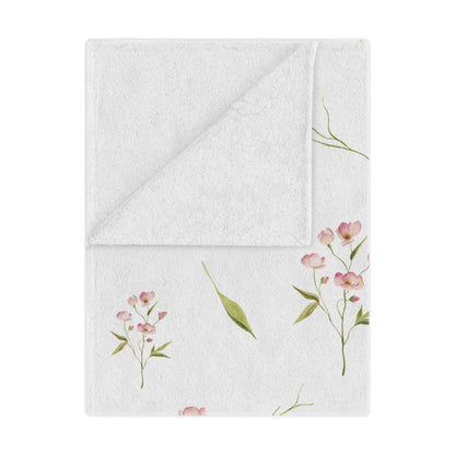 Blush Blossom minky baby blanket draped over a crib