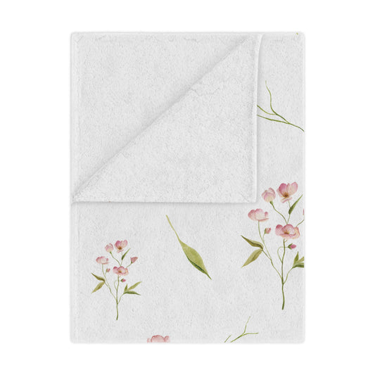Blush Blossom minky baby blanket draped over a crib