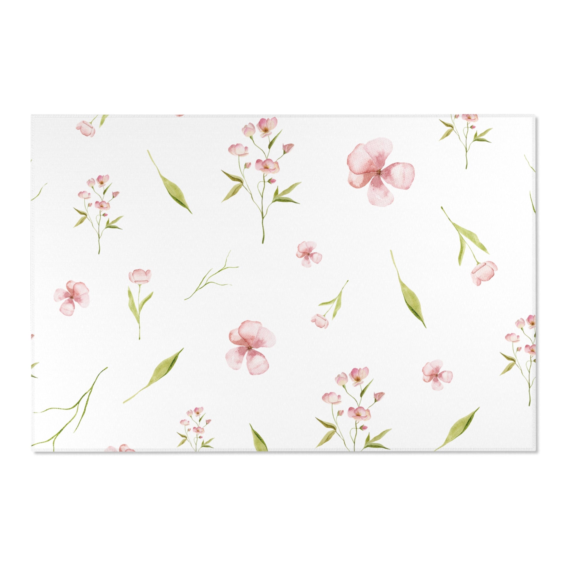 Pink and green floral nursery rug on a wooden floor