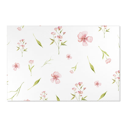 Pink and green floral nursery rug on a wooden floor