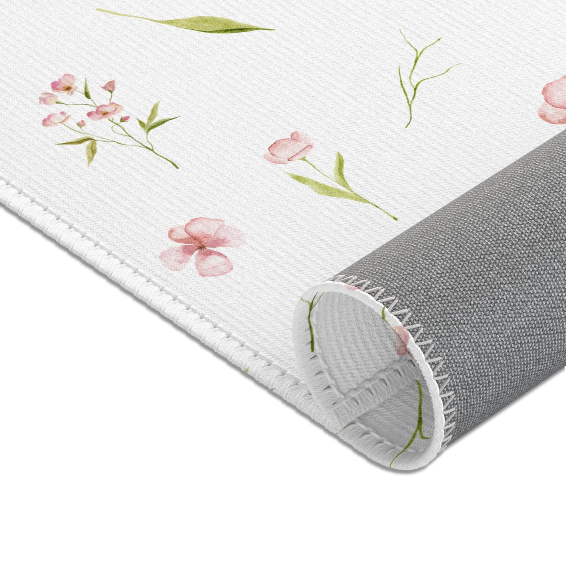 Dusty pink floral area rug beside a nursery crib