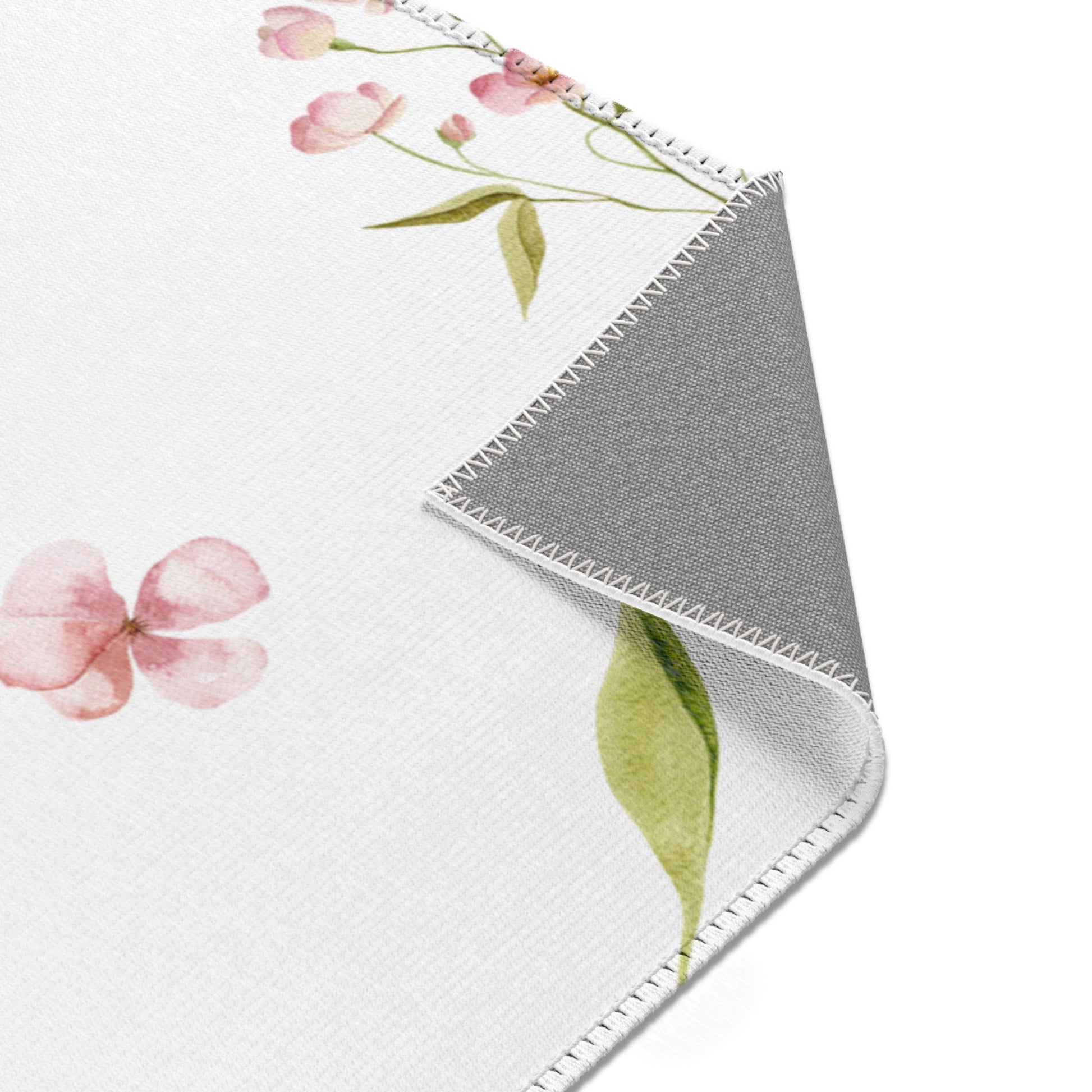 Blush Blossom floral area rug on a light wood floor
