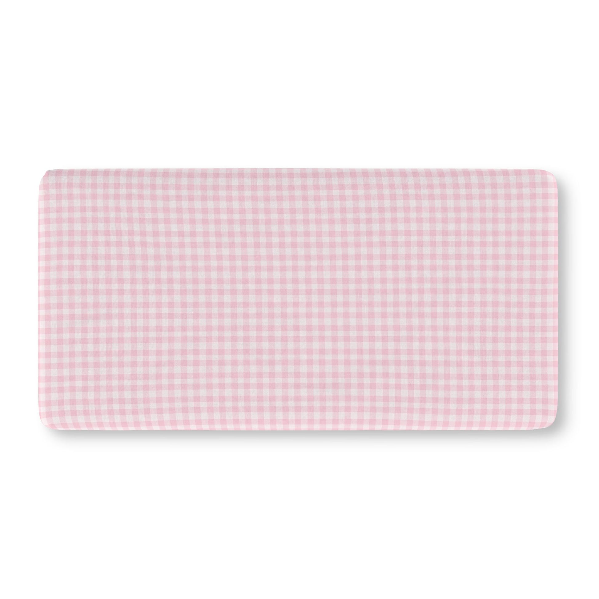 Pink gingham crib sheet on a standard crib mattress