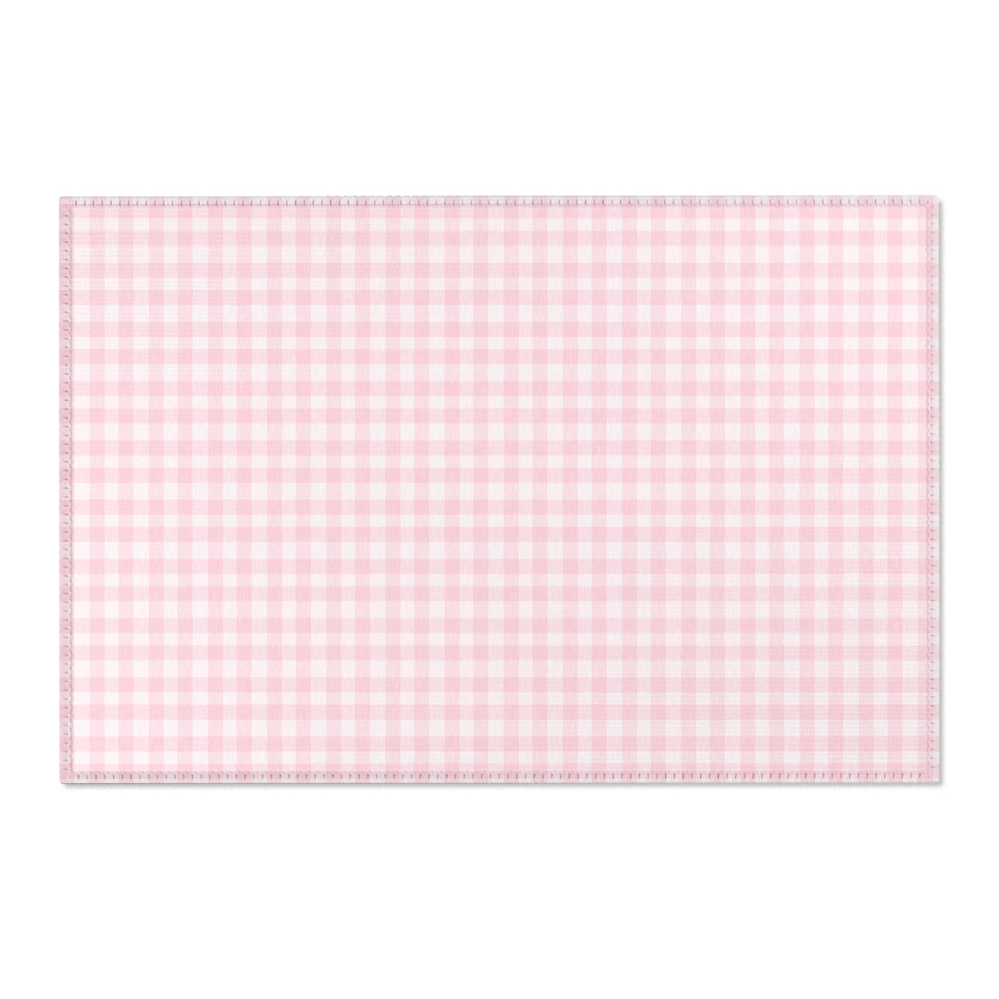 Pink gingham area rug beside a nursery crib