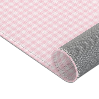Pink gingham nursery rug under a crib