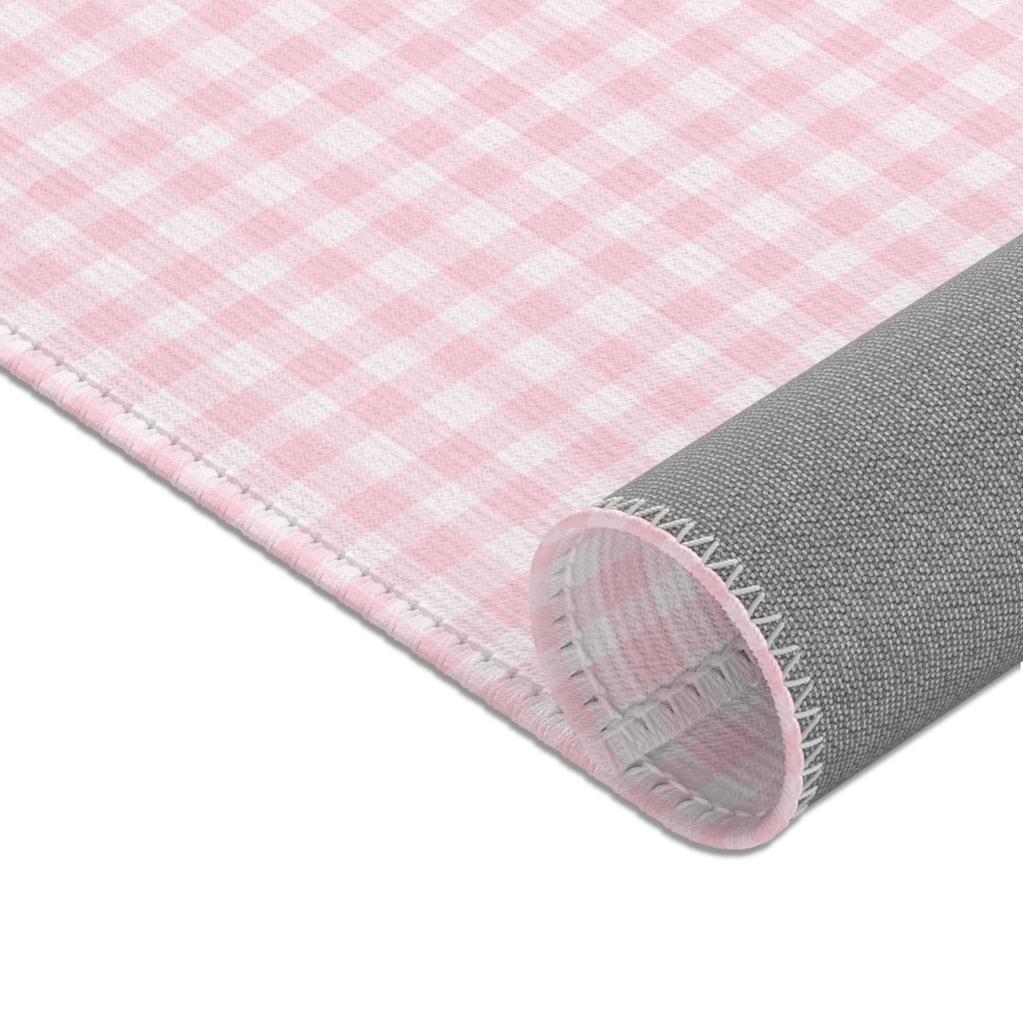 Pink check rug beside a nursery glider chair