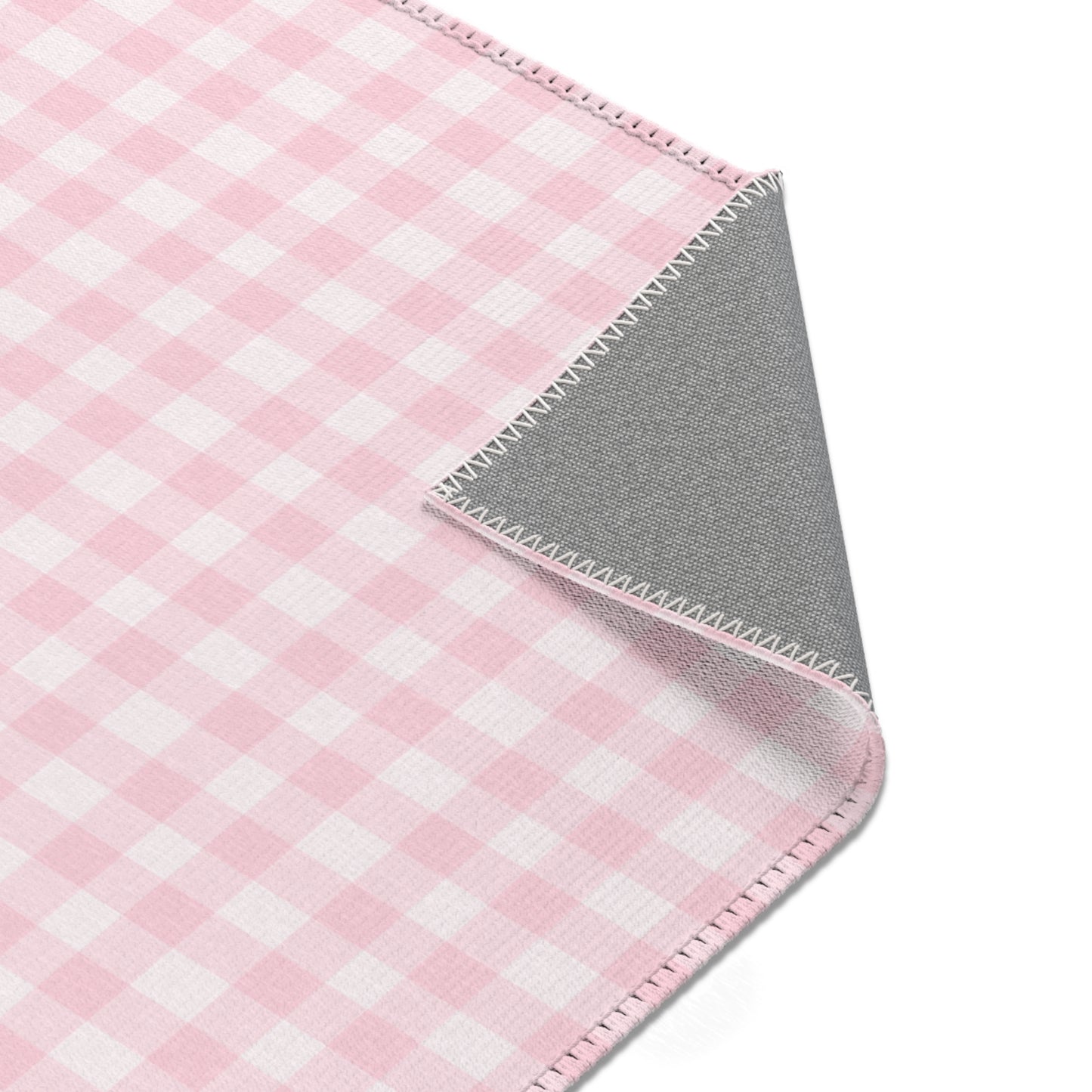 Pink and white check rug in a small baby room