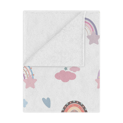 Confetti Rainbows minky baby blanket draped over a crib