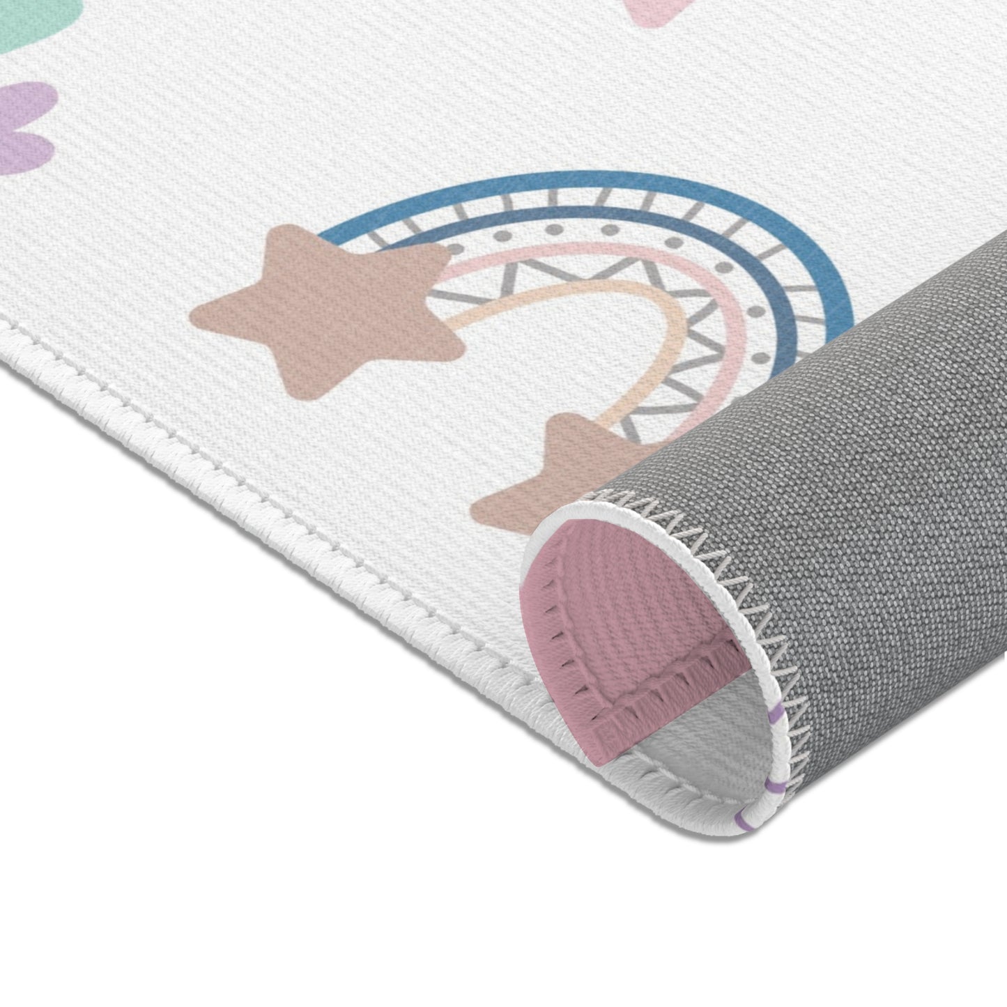 Rainbows, stars and hearts printed across the nursery area rug