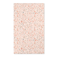 Small floral nursery area rug in coral on blush