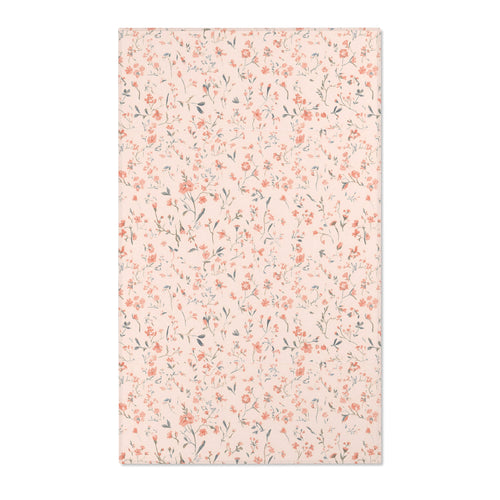 Small floral nursery area rug in coral on blush
