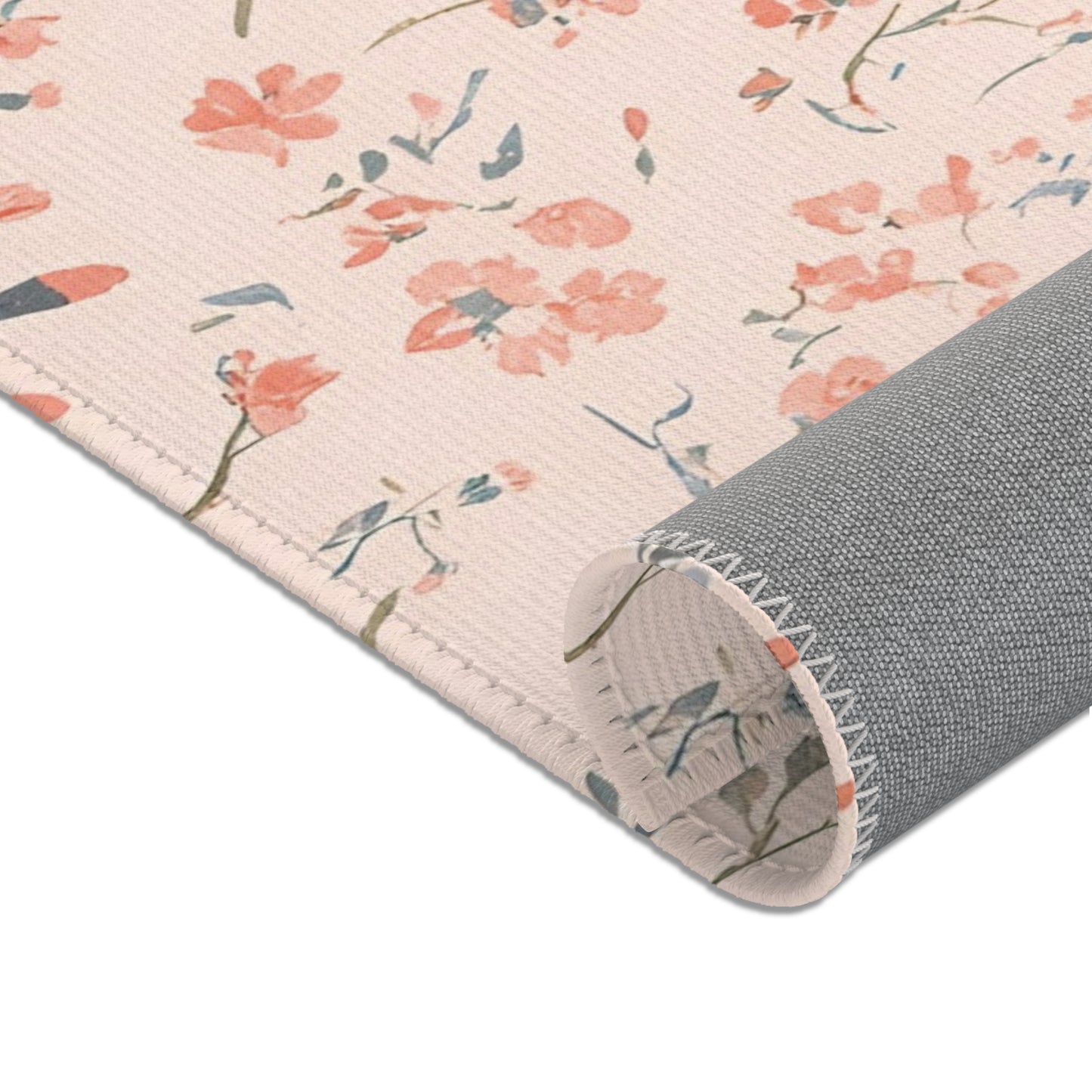 Nursery area rug in a coral, blush and sage palette