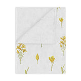 Golden Meadow minky baby blanket draped over a crib