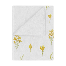 Golden Meadow minky baby blanket draped over a crib