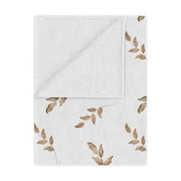 Linen Leaf minky baby blanket draped over a crib