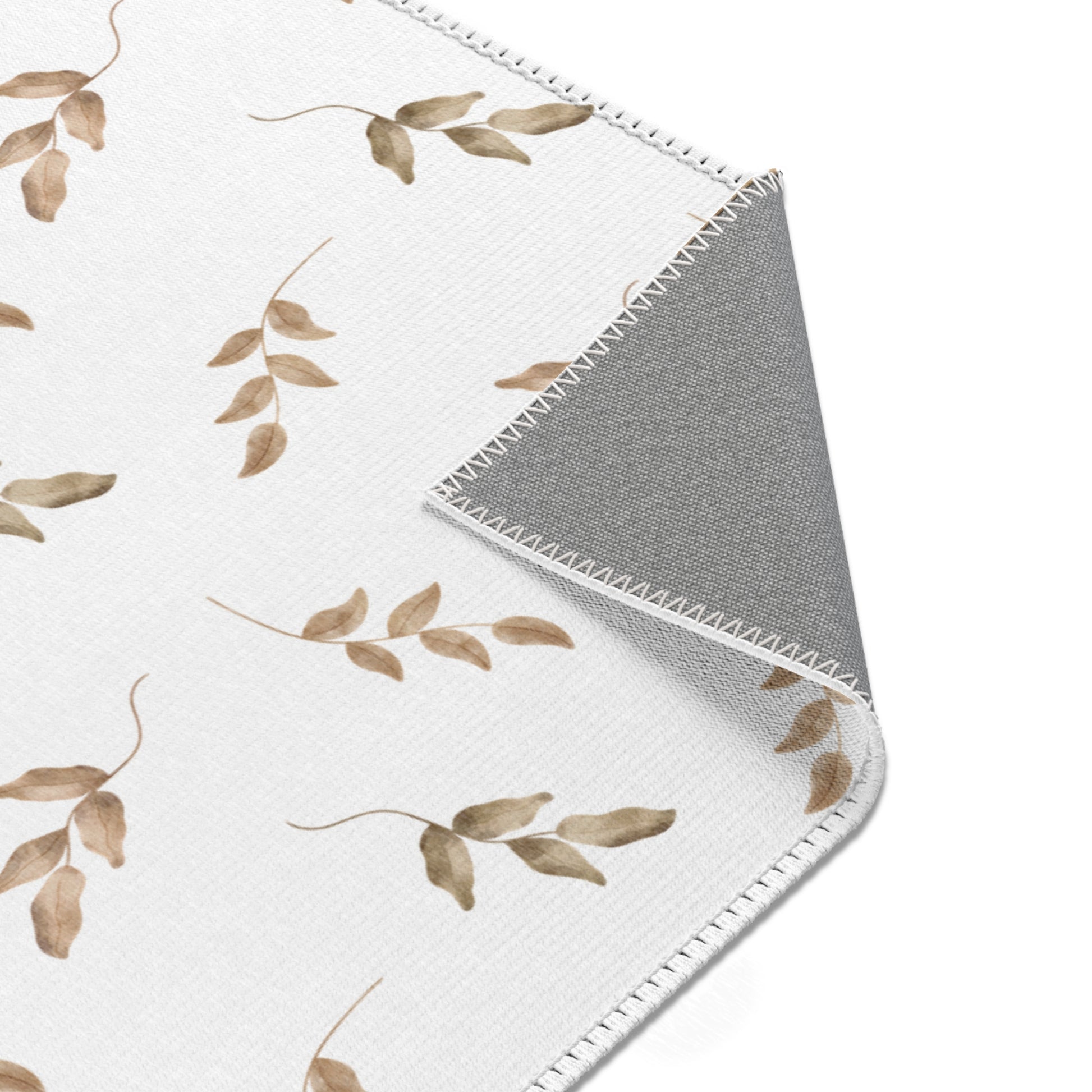 Neutral leaf print rug in taupe and olive for a nursery floor