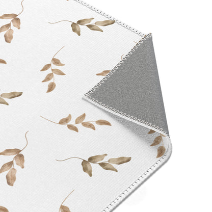 Neutral leaf print rug in taupe and olive for a nursery floor