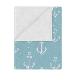 Nautical anchor minky baby blanket draped over a crib