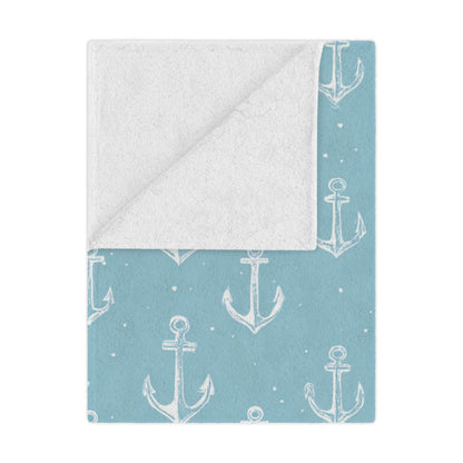 Nautical anchor minky baby blanket draped over a crib
