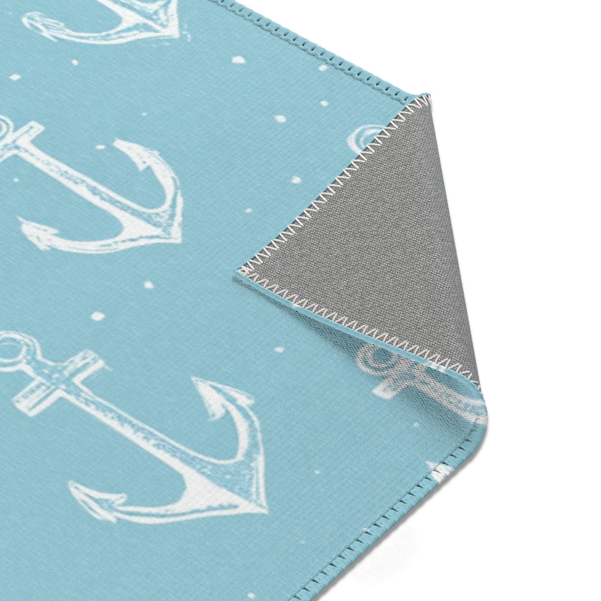 Teal anchor print rug on a light wood floor