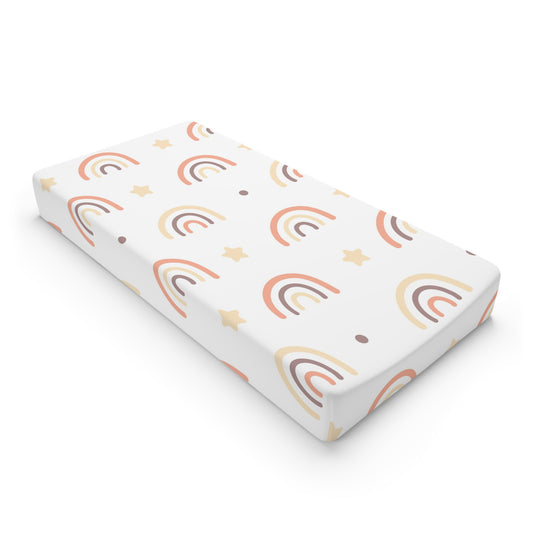 Peach Rainbow changing pad cover on a nursery changing table