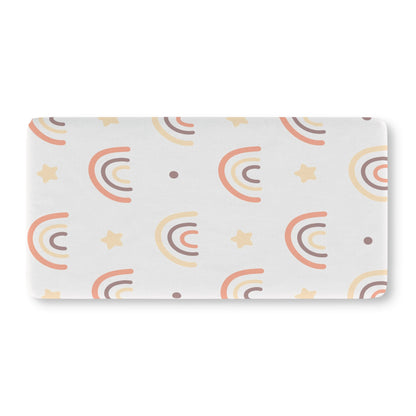 Fitted crib sheet with hand-drawn peach and cream rainbows