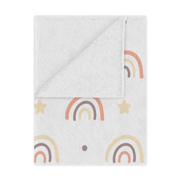 Peach Rainbow minky baby blanket draped over a crib