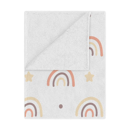 Peach Rainbow minky baby blanket draped over a crib
