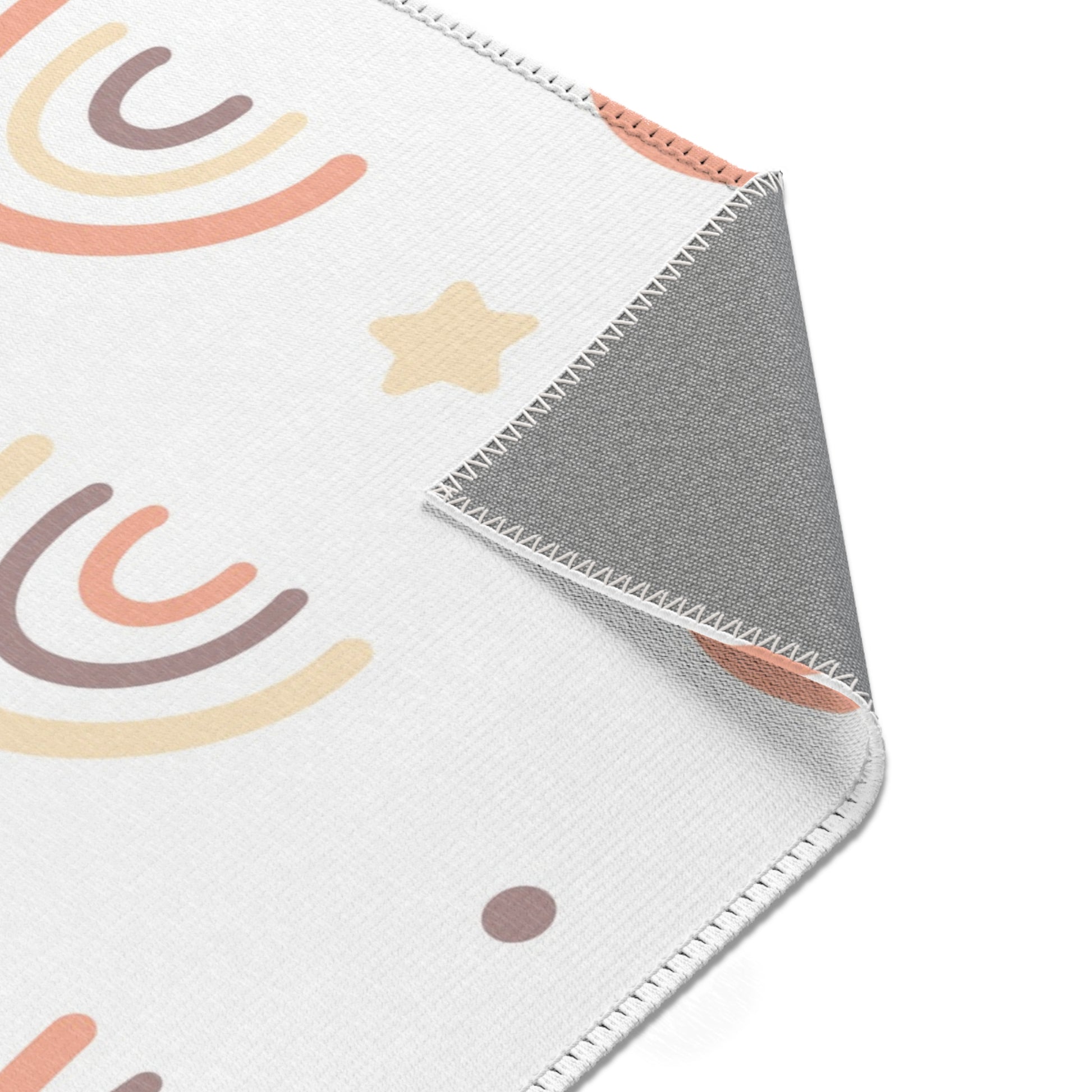 Rainbow rug in peach and cream on white for a nursery floor