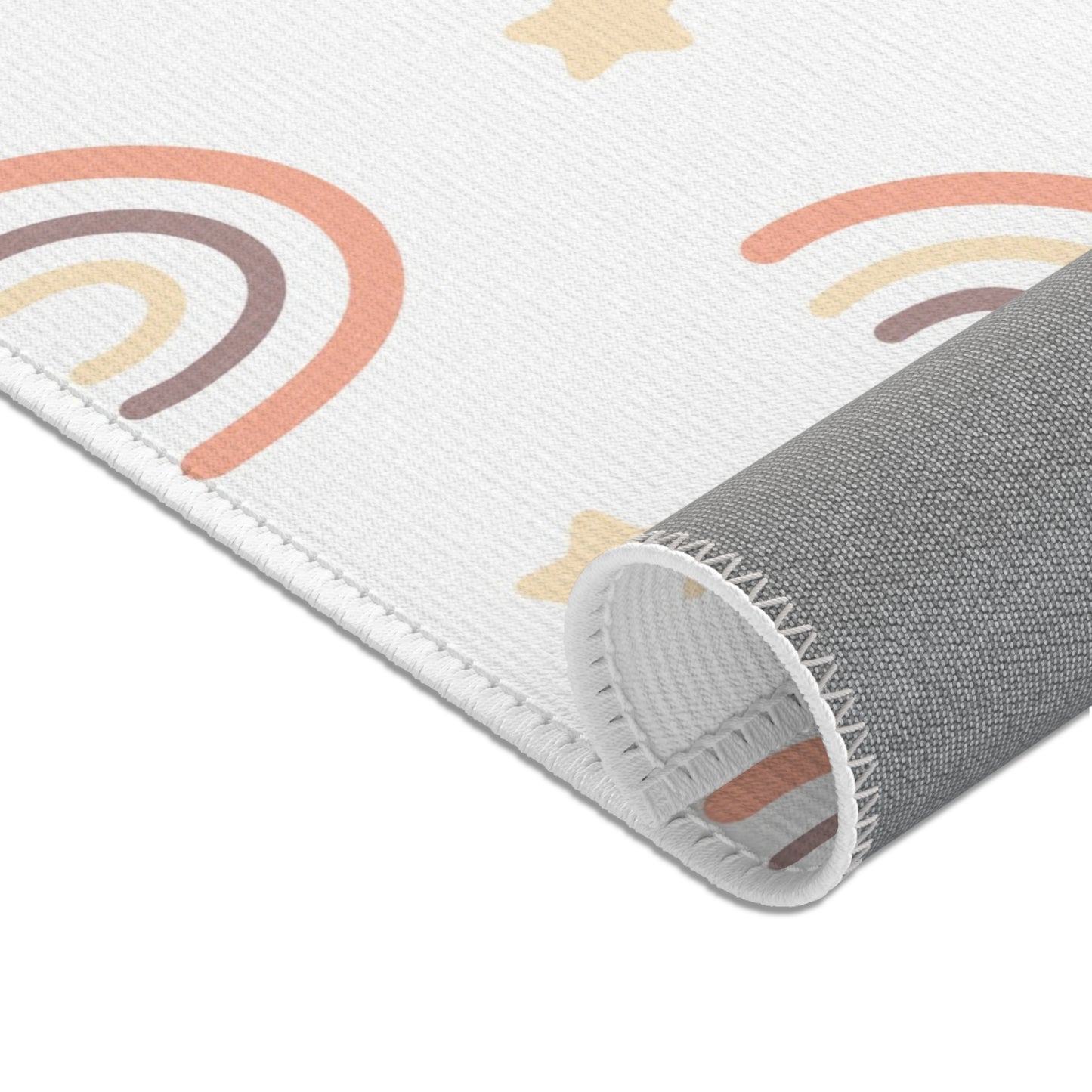 Rows of outlined rainbows printed across the nursery area rug