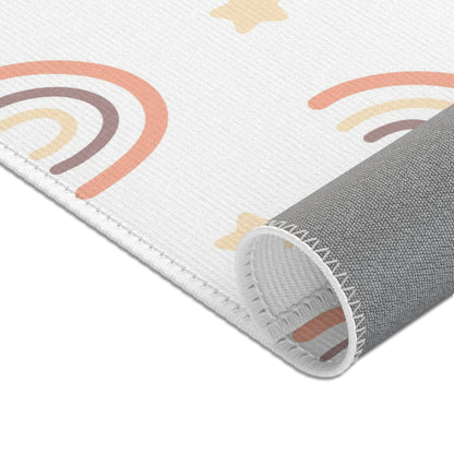 Rows of outlined rainbows printed across the nursery area rug
