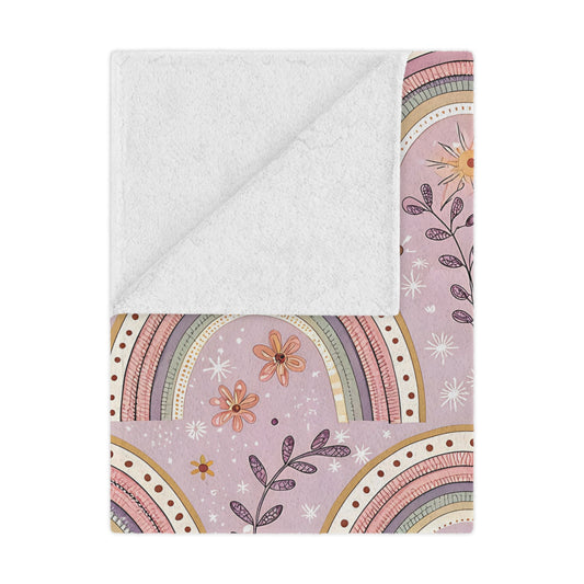 Petal Arches minky baby blanket draped over a crib
