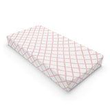 Pink trellis changing pad cover on a nursery changing table