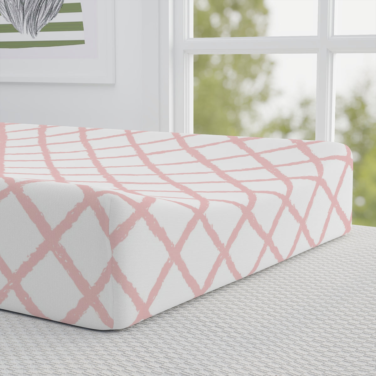 Close-up of the pink trellis print on a changing pad cover