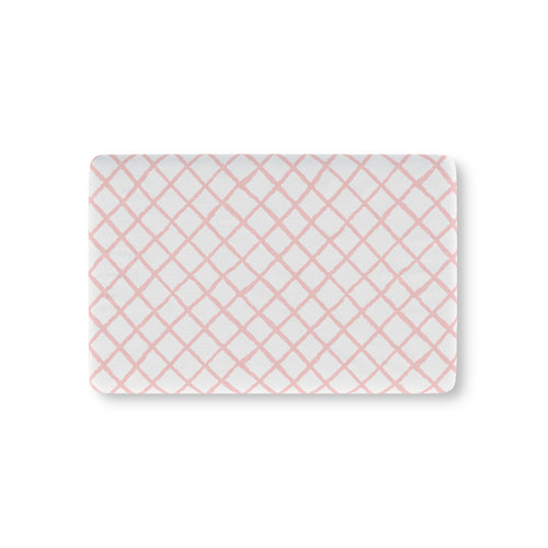 Pink trellis fitted crib sheet on a nursery crib mattress
