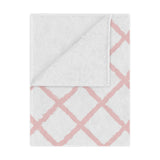 Pink trellis minky baby blanket draped over a crib