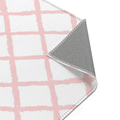 Pink trellis rug beside a nursery glider chair