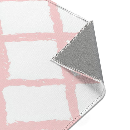 Soft pink lattice rug on a light wood floor