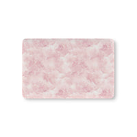 Pink watercolor clouds fitted crib sheet on a nursery crib mattress