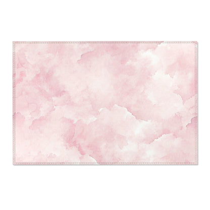 Washable pink watercolor clouds area rug under a nursery crib
