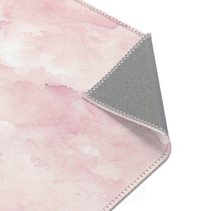 Pink watercolor clouds rug beside a nursery glider chair